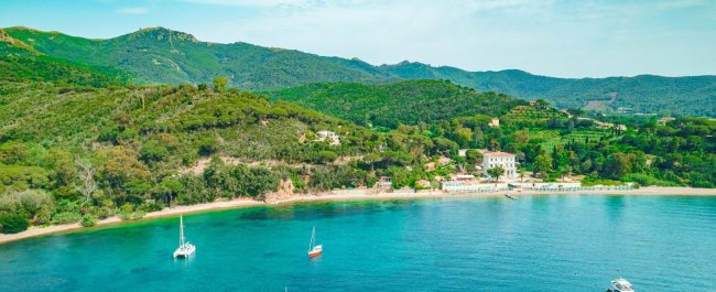 Spiaggia e colline verdi viste dall'alto.