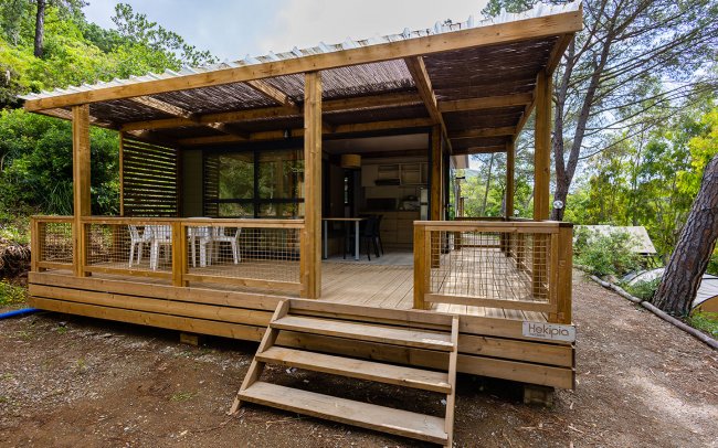 Bungalow in legno con ampia veranda immerso nel verde.