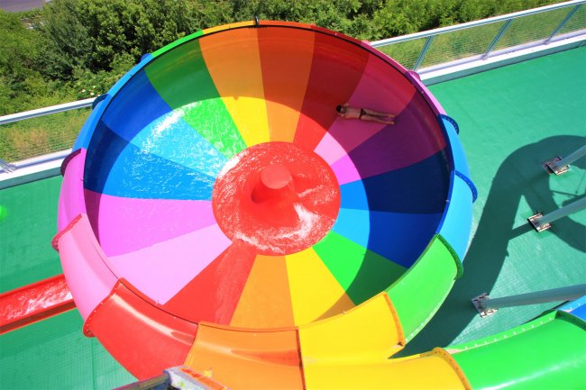 Scivolo d'acqua a spirale multicolore con una persona che scende.