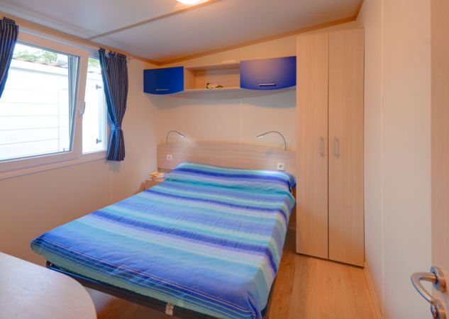Camera con letto matrimoniale e tende blu.