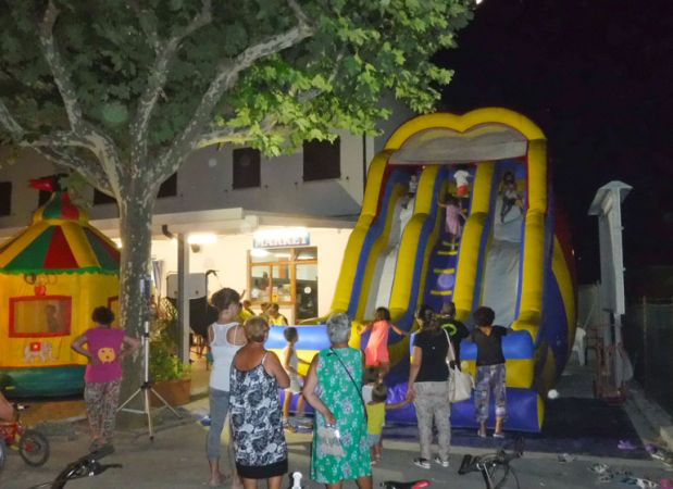 Persone e giochi gonfiabili di notte in piazza.