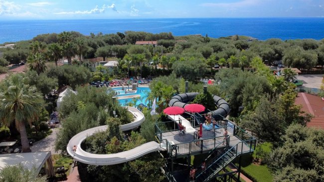 Veduta aerea di un acquapark con scivoli e piscine vicino al mare.