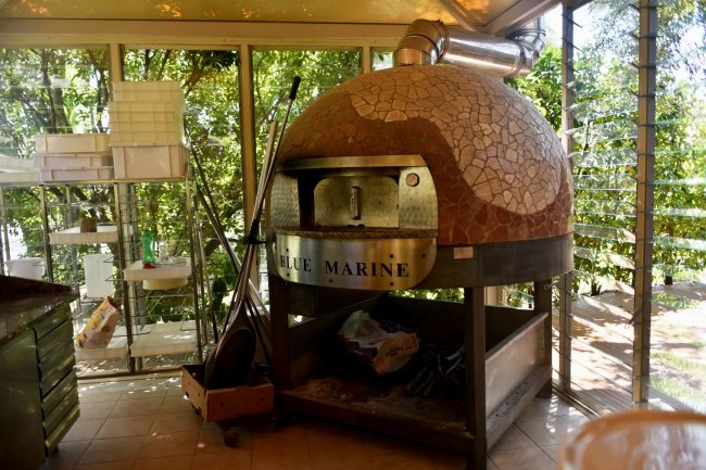 Forno a legna in una cucina con vetrate.