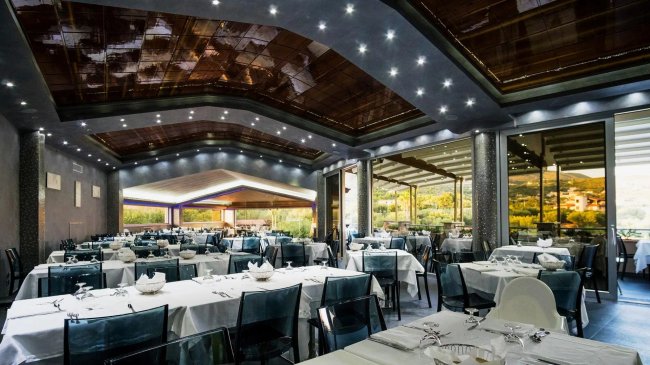 Interno di ristorante elegante con tavoli apparecchiati.