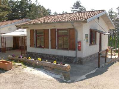 Edificio con tetto a tegole rosse e finestre con persiane marroni.